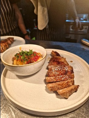 Sliced pork with patatas bravas served as a main course at a Chesil Rectory wine dinner in Winchester